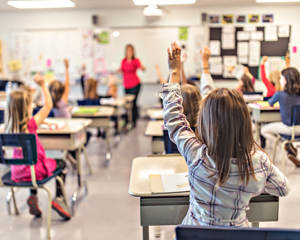classroom with students raising hands during a lesson teacher engaging with students education learning